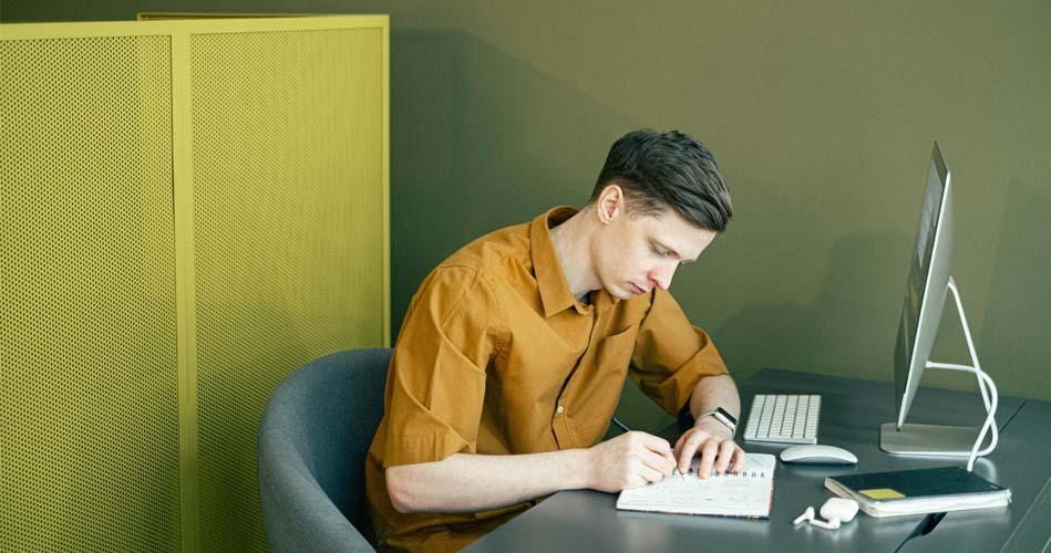 Boy making notes on Revenue Talati from his PC